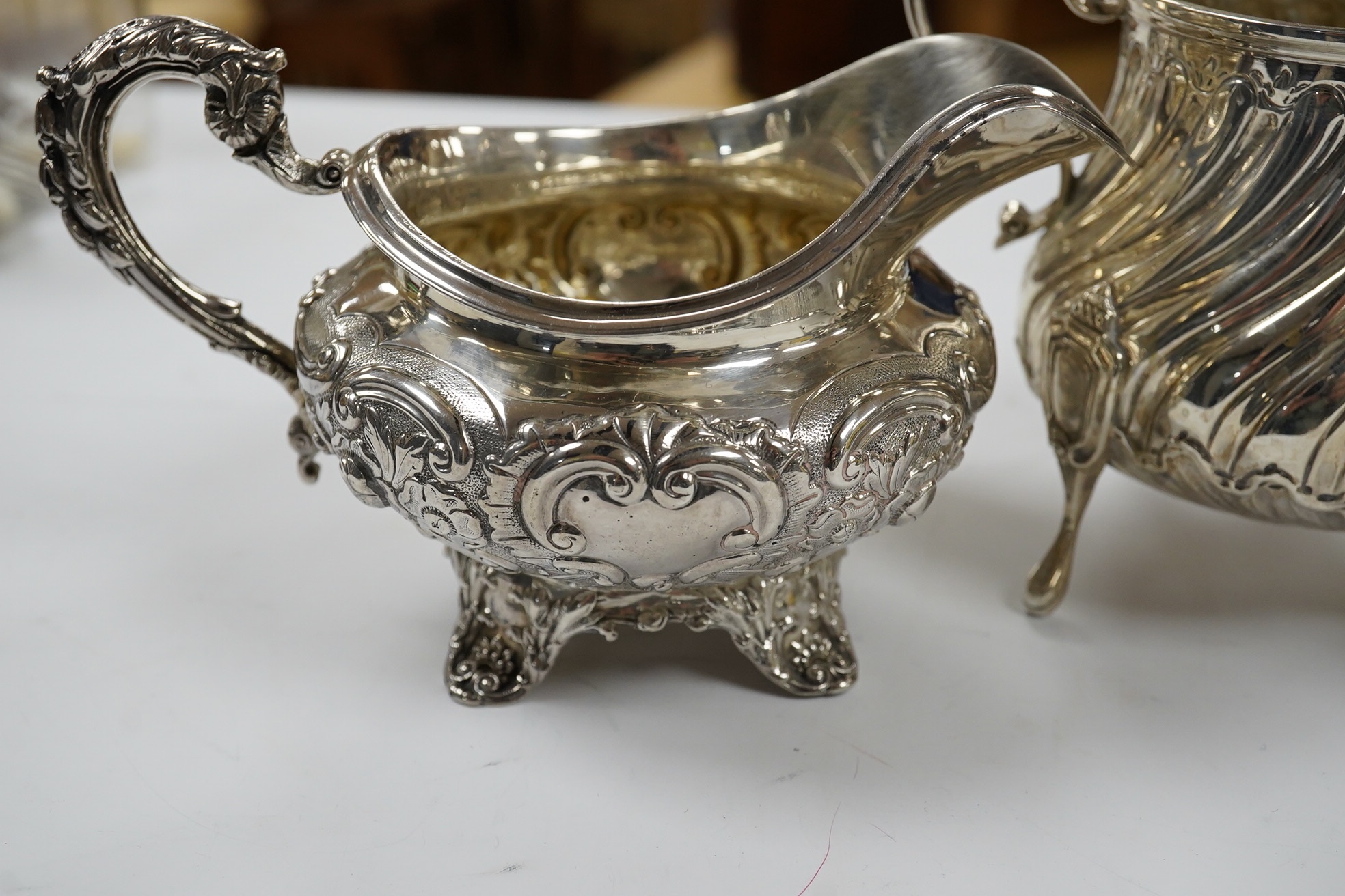 A late Victorian silver cream jug and sugar bowl, by Mappin & Webb, London, 1900 and an earlier William IV silver cream jug, London, 1835, 16.1oz. Condition - fair to good